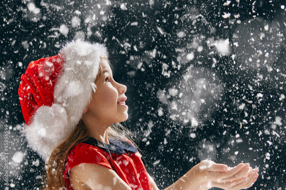 little girl catching snowflakes