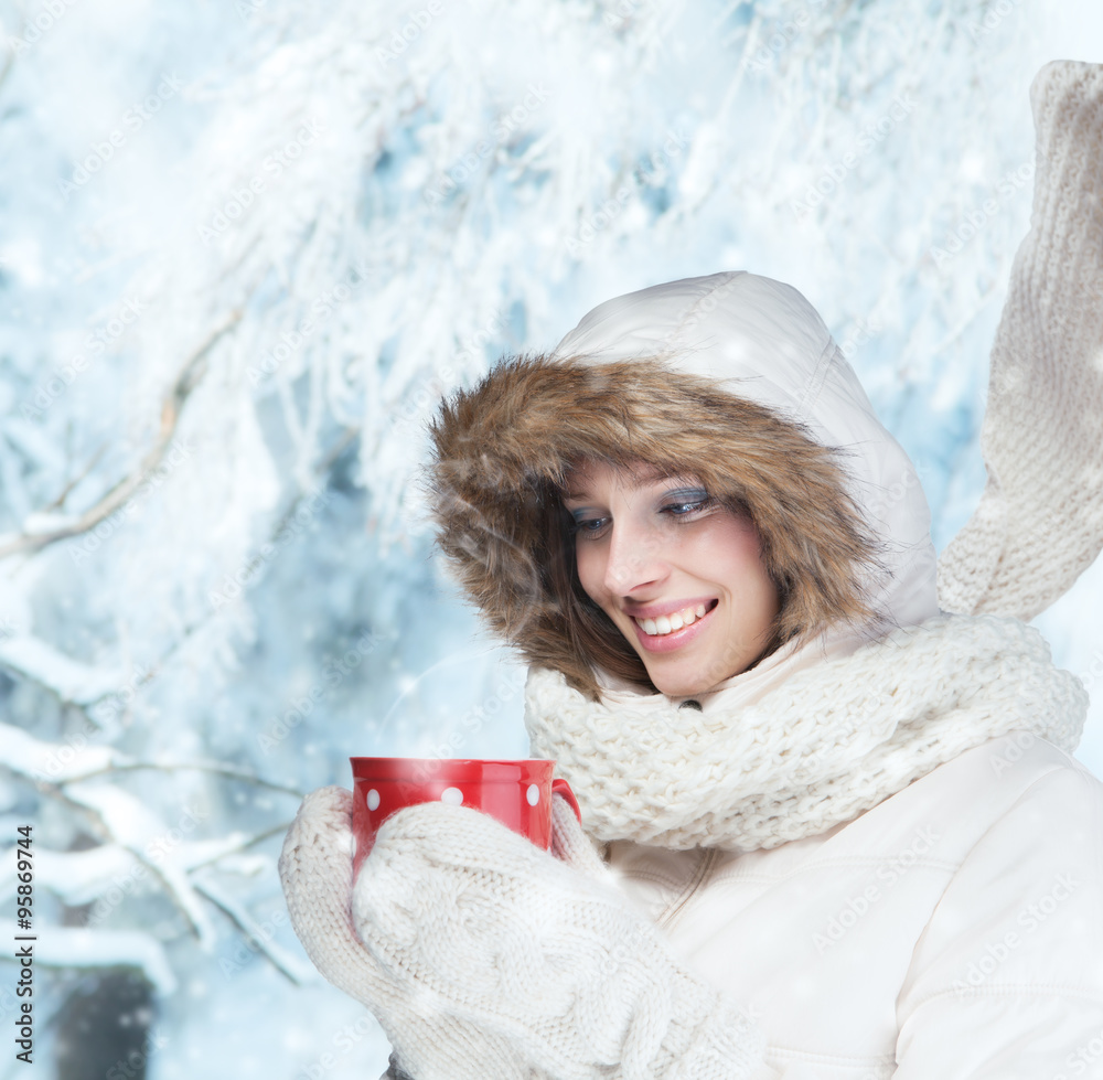 Beautiful brunette woman with cup in winter scenery