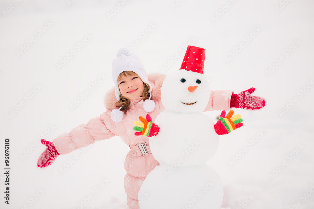 Child and snowman in winter