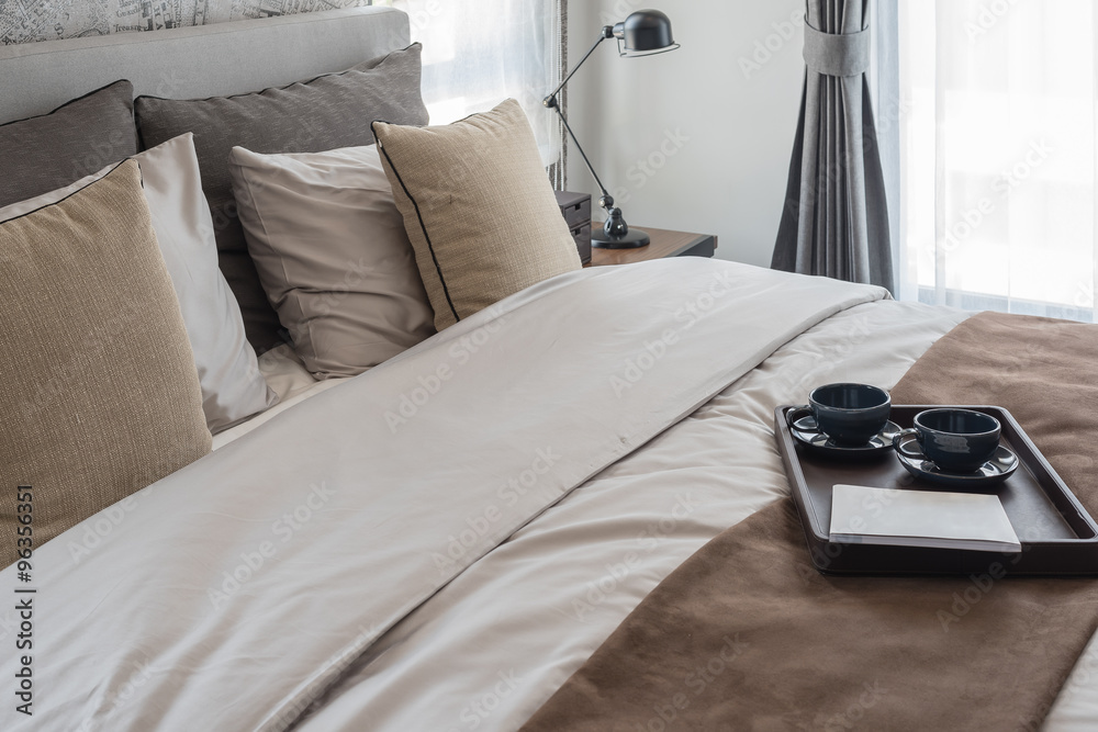 tray of black cup of coffee set on bed