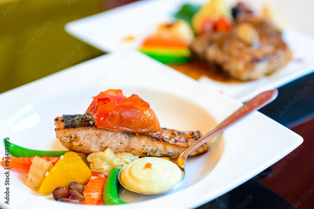 Pork steak with vegetables on white plate