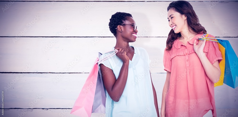 Composite image of female friends holding shopping bags