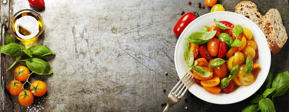 Fresh tomatoes with basil leaves in a bowl