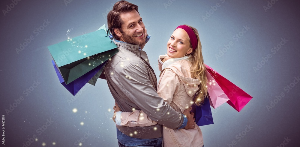 Composite image of smiling couple with shopping bags embracing