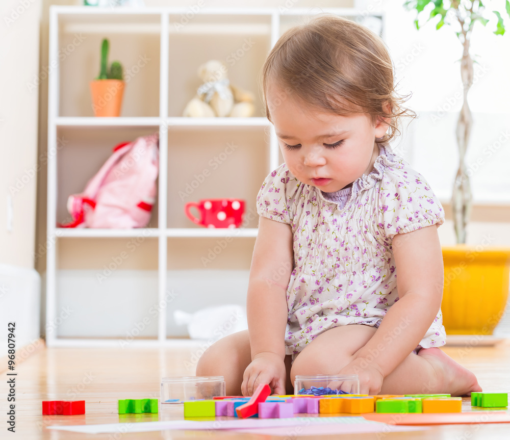 Cute toddler girl playing with her toys