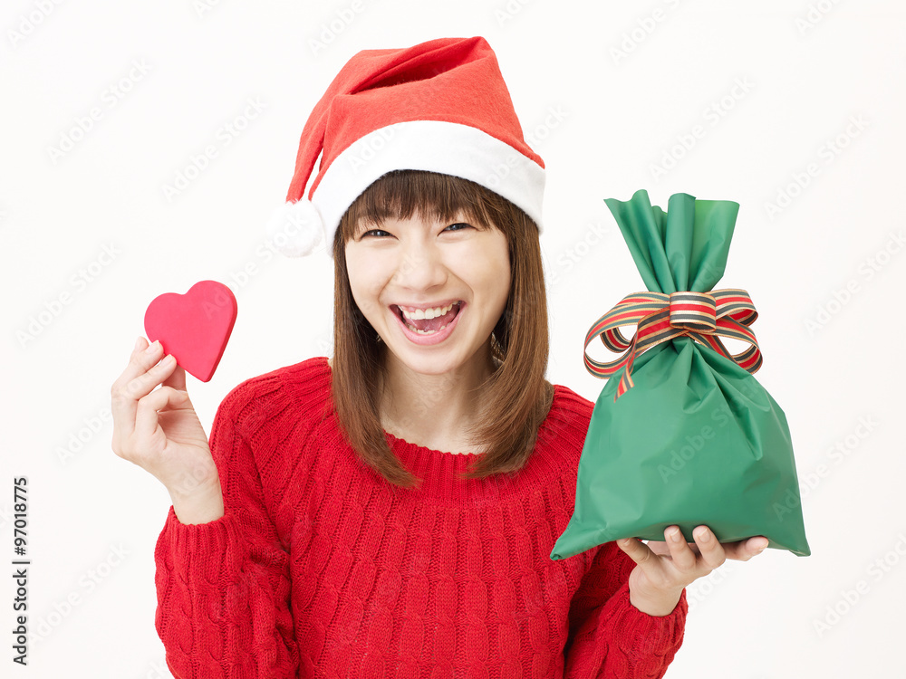 サンタ帽子をかぶる女性　クリスマスプレゼントとハートを持つ