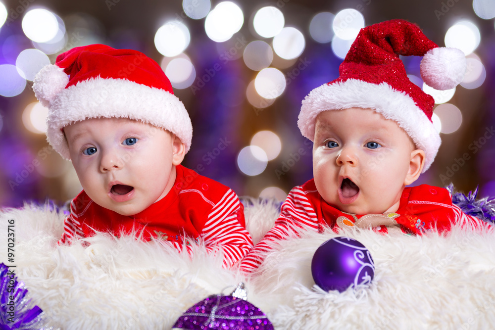 Baby twins in santa costumes for Christmas