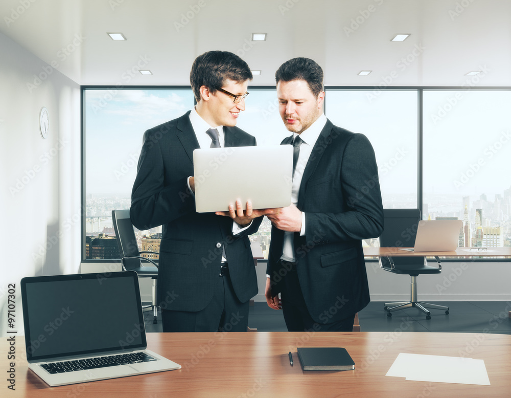 Businessmen with laptop discussing something in the office