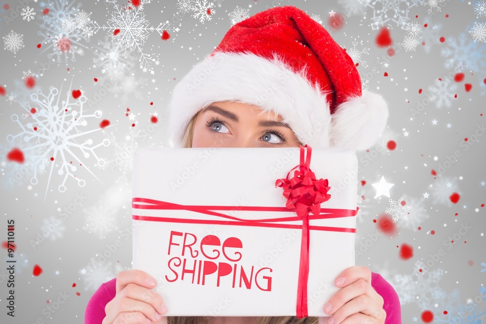 Composite image of festive blonde holding christmas gift