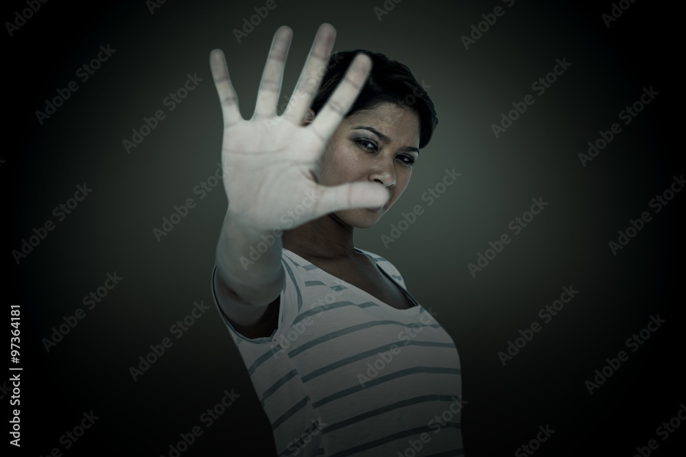 Composite image of serious woman making stop sign