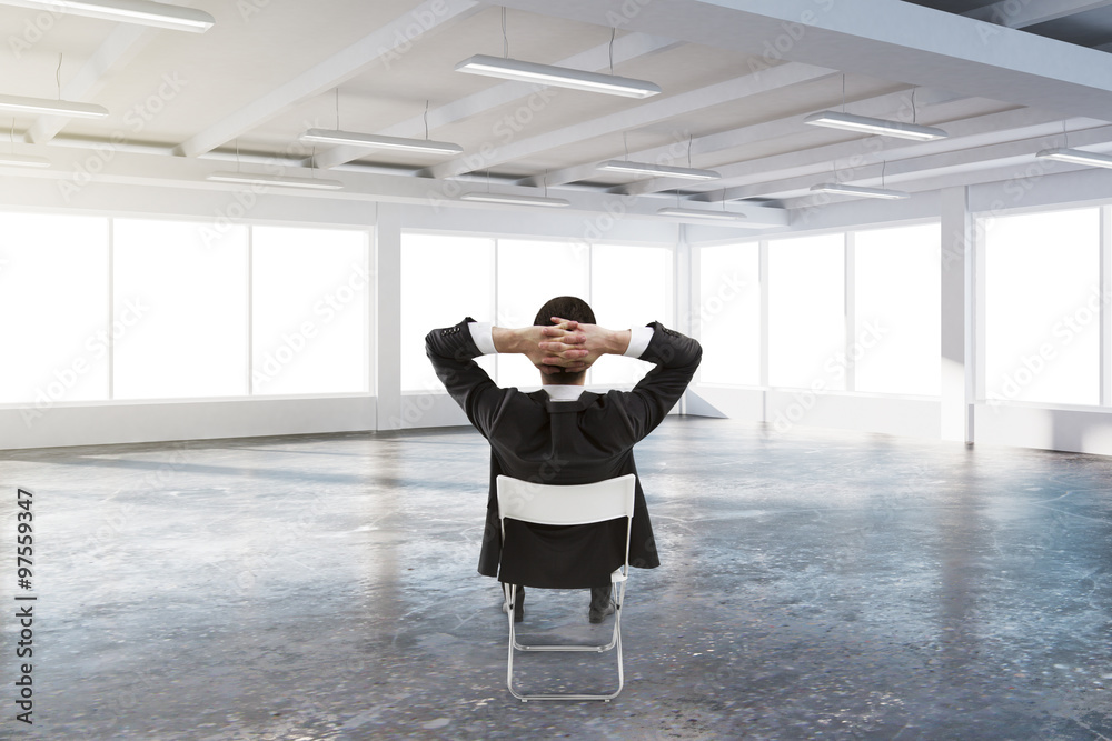 Businessman sitting on the chair in the center of sunny spacious