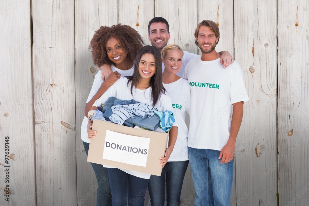 Happy group of volunteers holding donation box