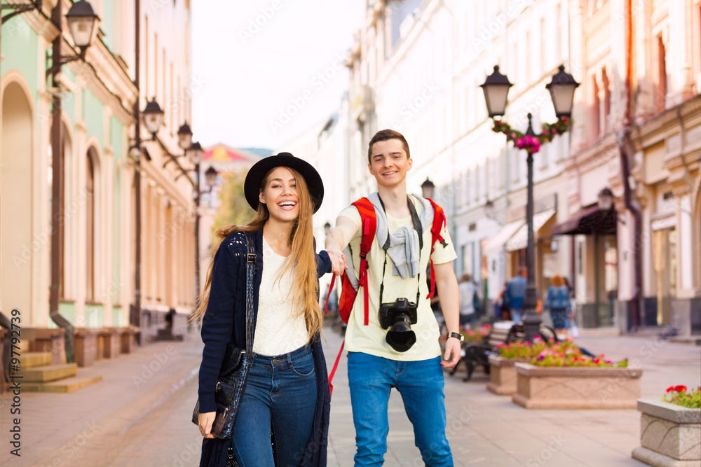 Happy girl holds hand of young man walking forward