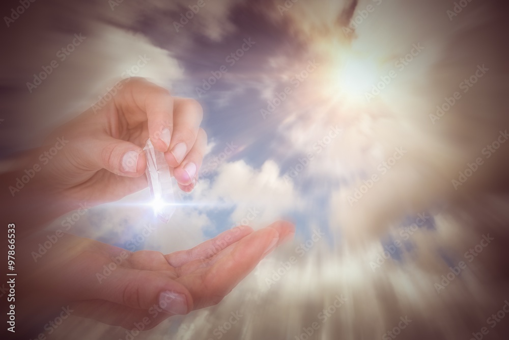 Composite image of woman holding precious gem