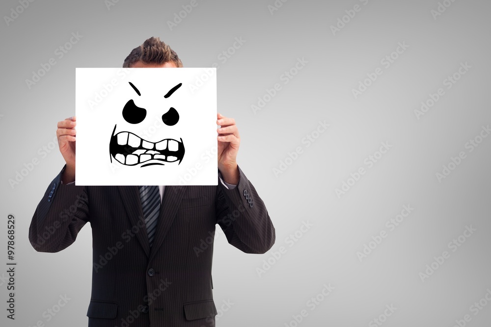 Businessman covering face with paper with angry face