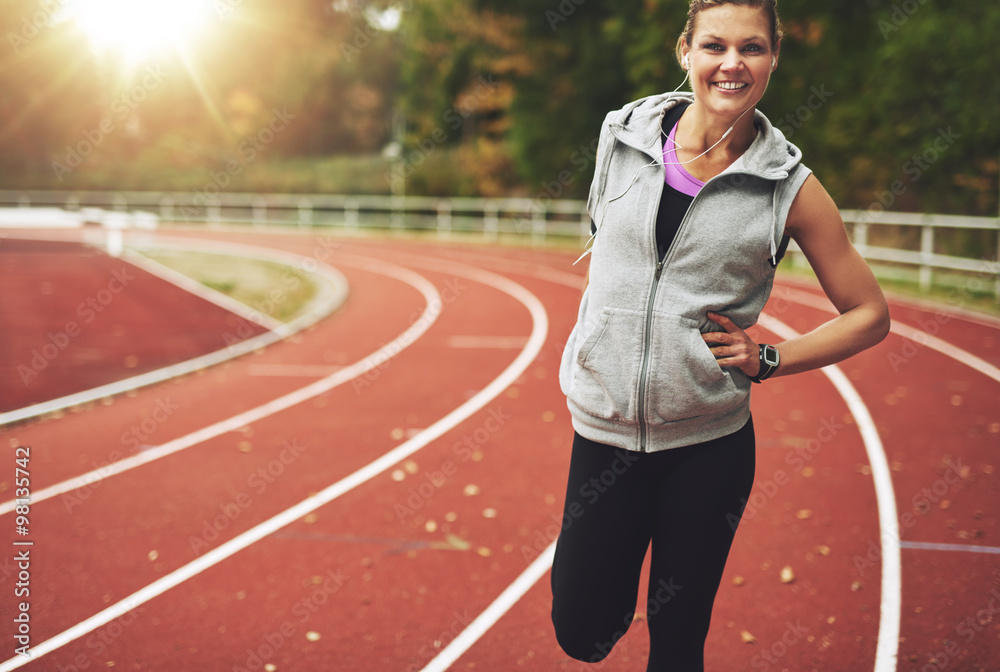 Fit woman smiling at camera while stretching