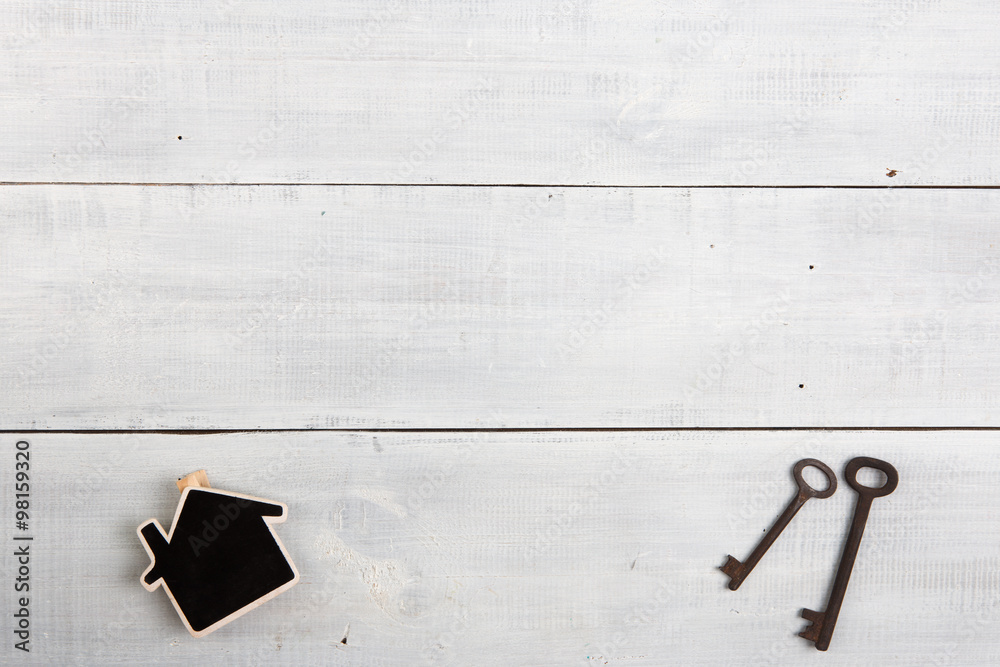 Real estate concept - little house and keys on white wooden desk