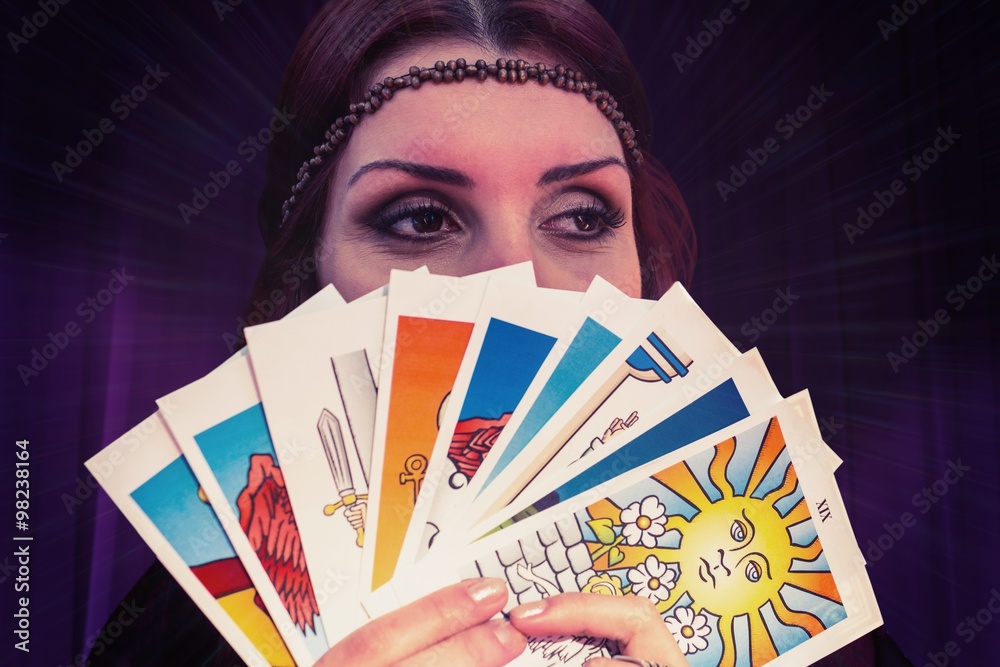 Composite image of fortune teller holding tarot cards