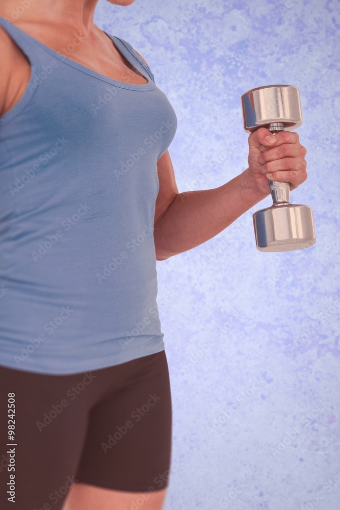 Composite image of muscular woman exercising with dumbbells 