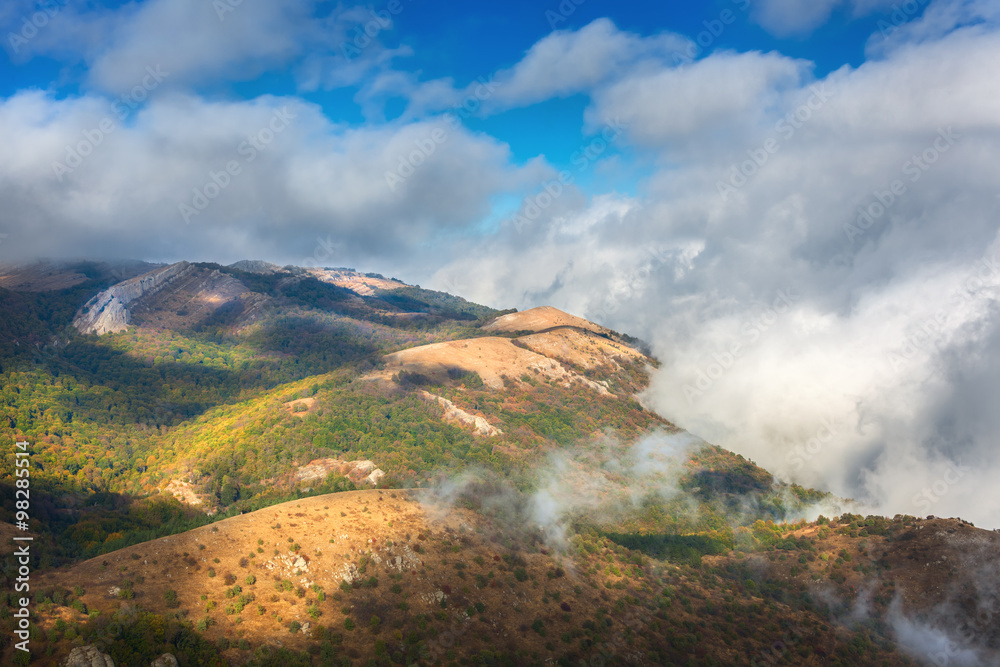 日落时的戏剧性山景。低云