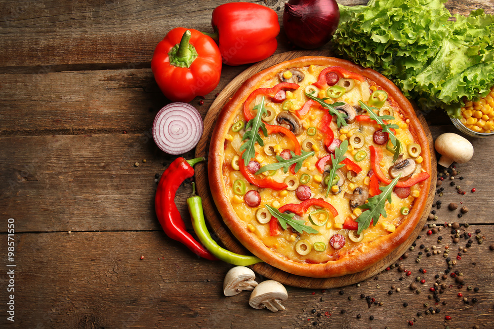 Delicious pizza with vegetables on wooden background