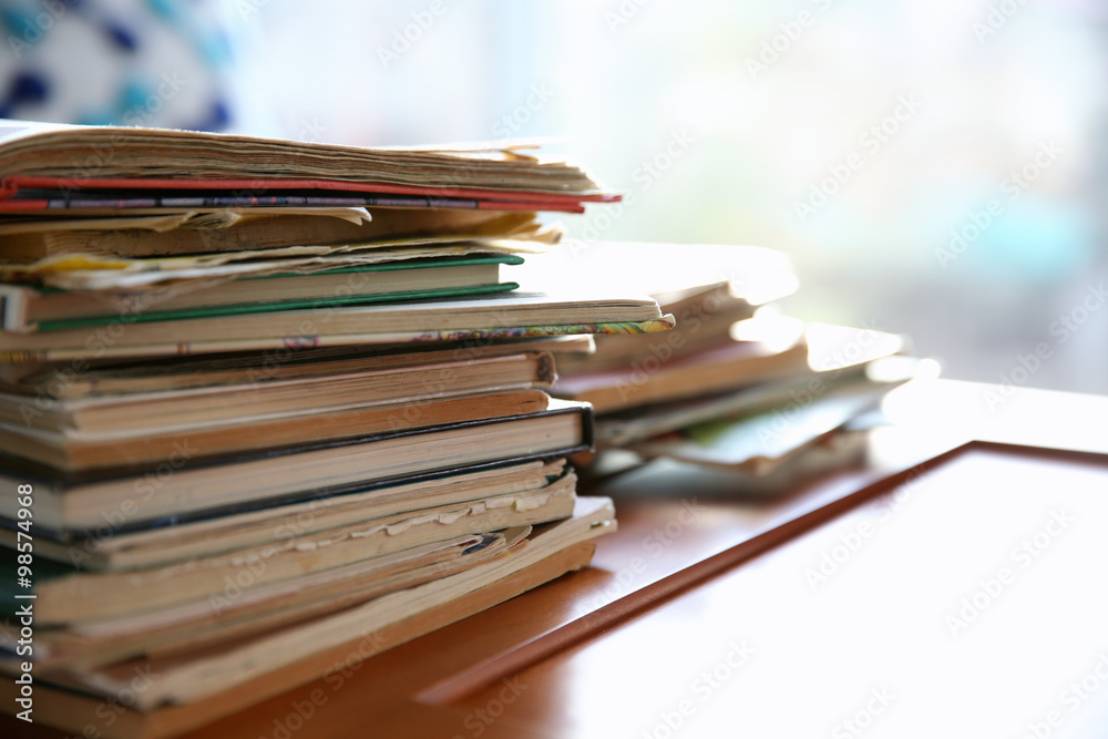 Pile of old books on brown table in the room, close up