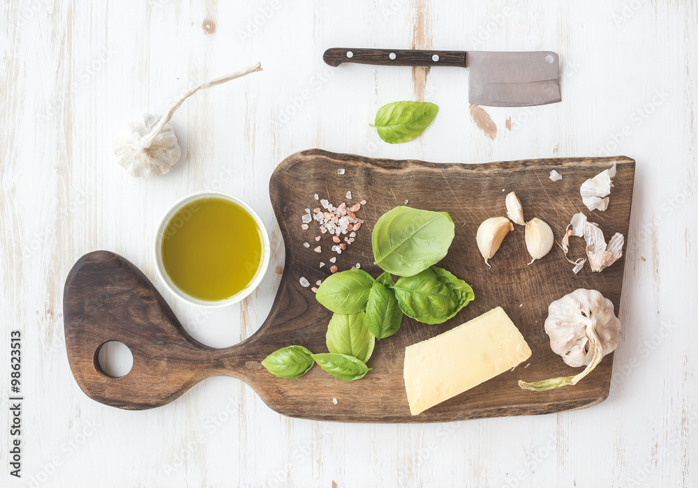 Pesto sauce cooking set. Fresh basil, olive oil, parmesan cheese and garlic on rustic walnut choppin