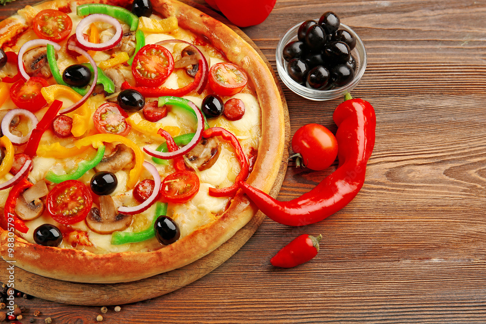 Delicious pizza with vegetables, on wooden table