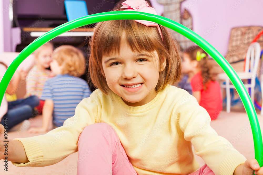 Smiling little girl sit with hoop smile and happy