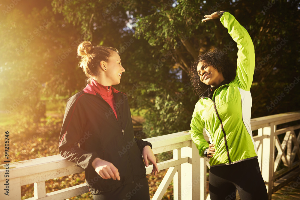 Two sportswomen stretching