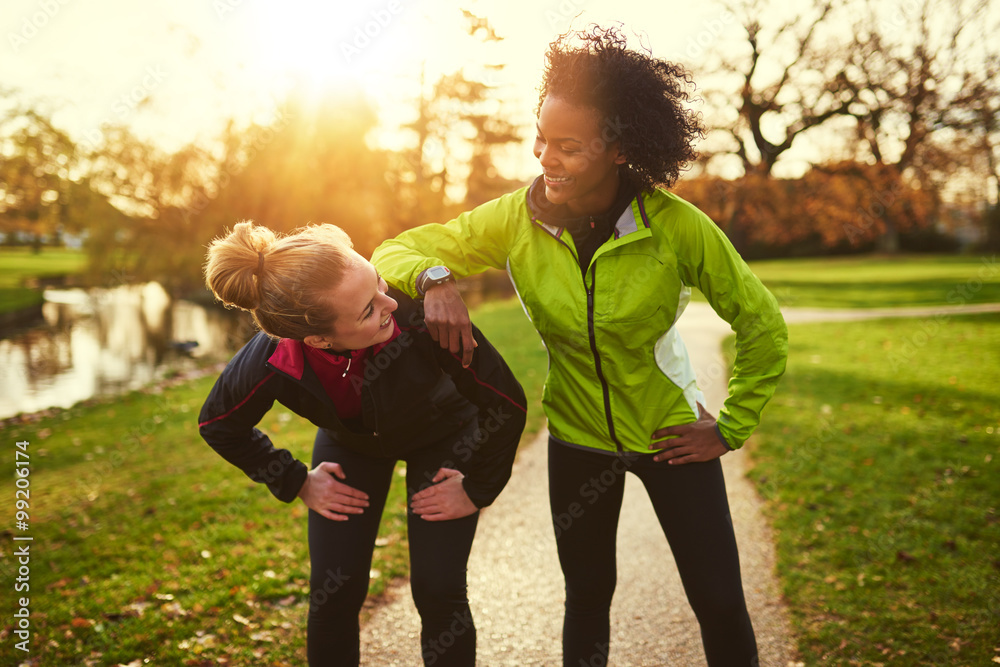 Two sportswomen relaxing after jogging