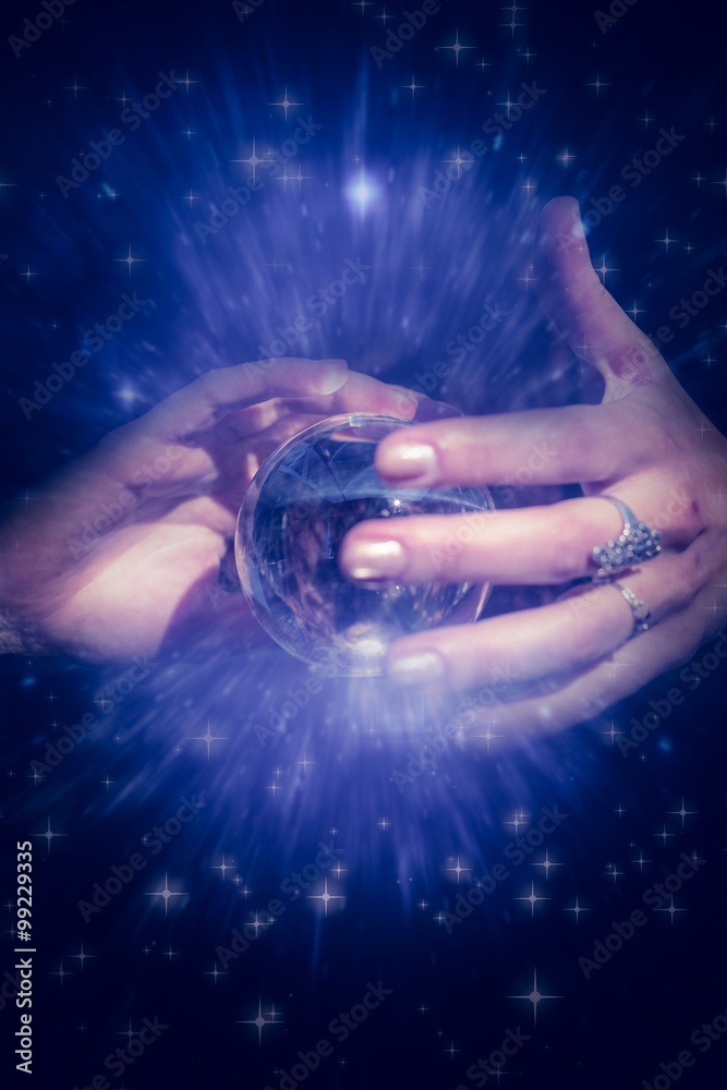 Composite image of woman using crystal ball 