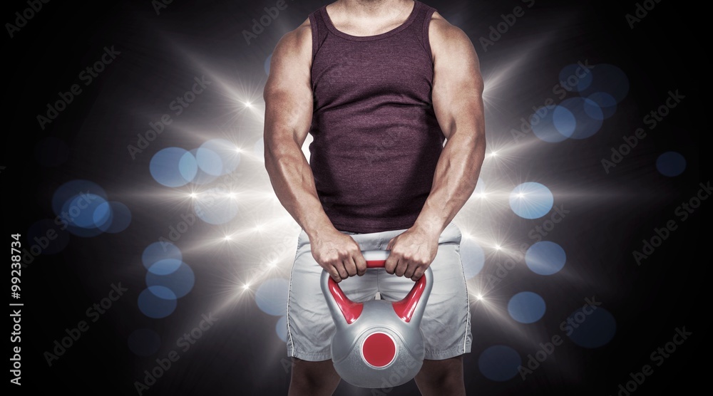 Composite image of muscular serious man holding a kettlebell