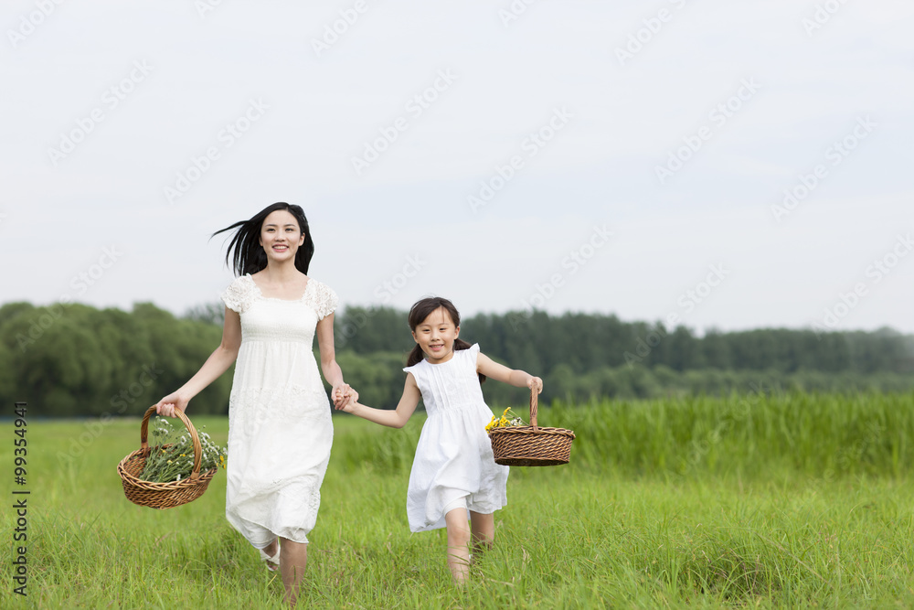 兴奋的母女在草地上奔跑