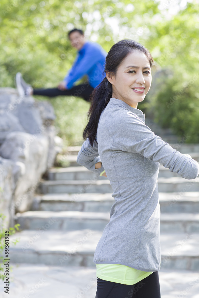 Happy mature woman exercising in park