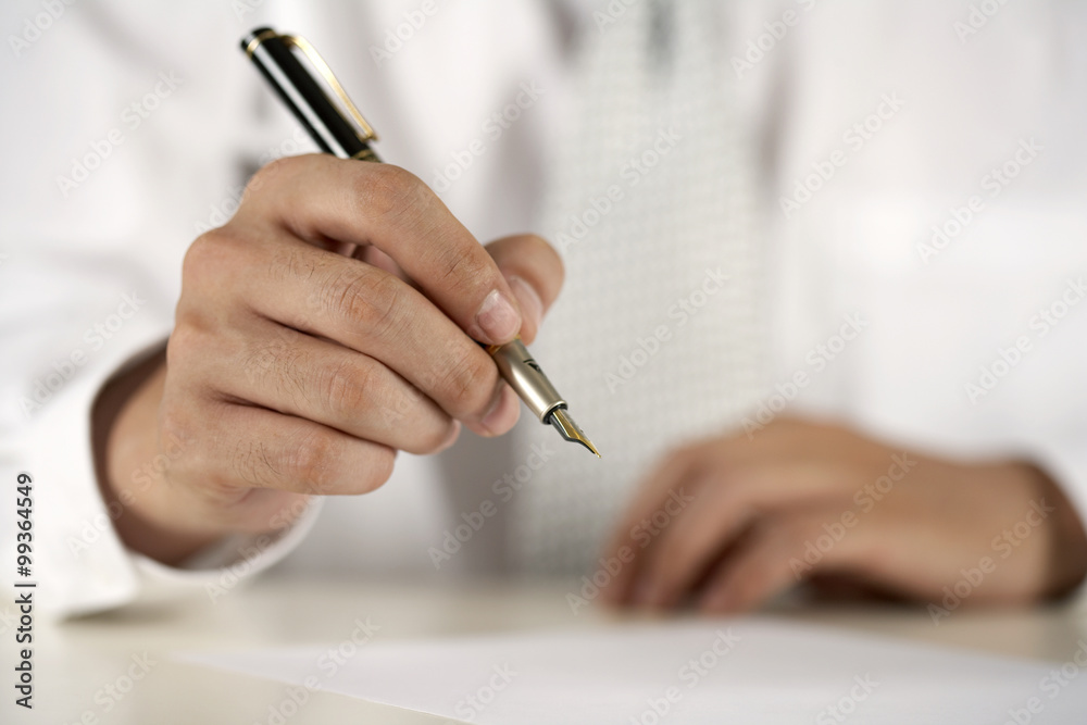 A businessman prepares to sign a document