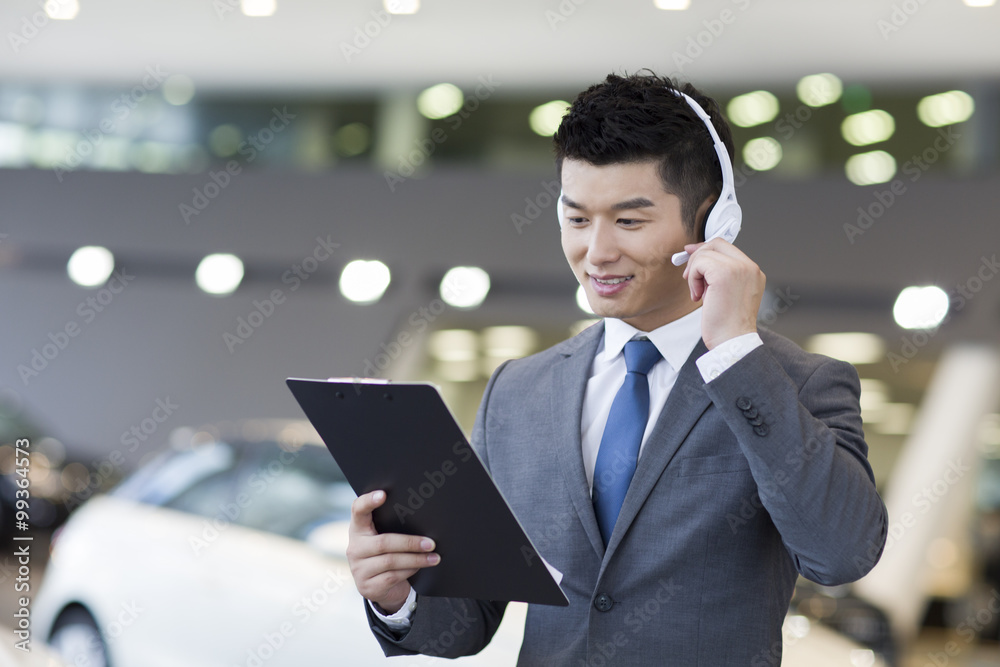 Confident car salesman with headset