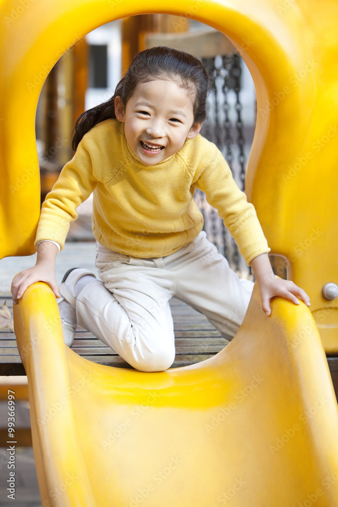 Girl playing on playground slide