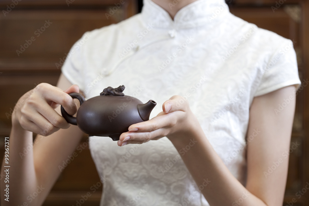 Young woman holding a Chinese boccaro teapot