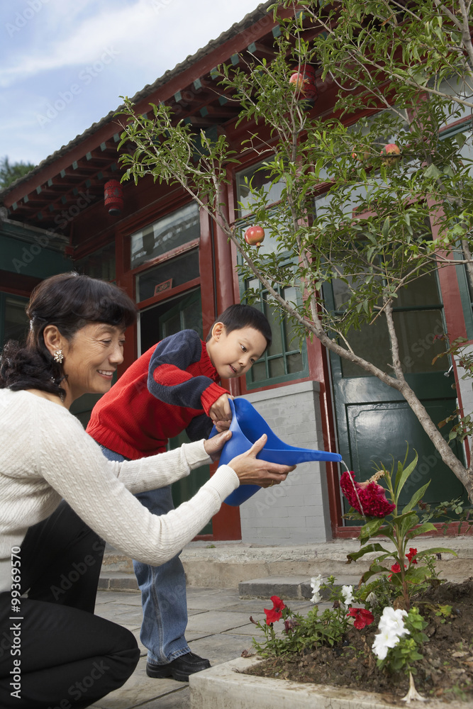 祖母和孙子给花园浇水