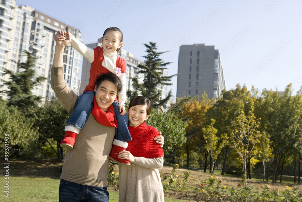 年轻的一家人在秋天享受公园