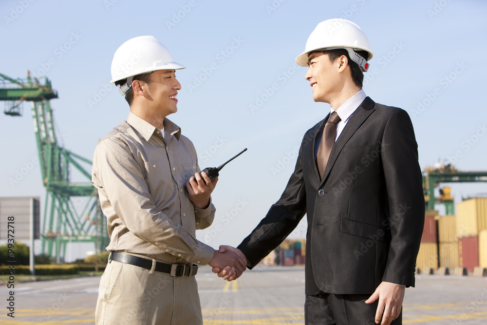 businessman and shipping industry worker shaking hands