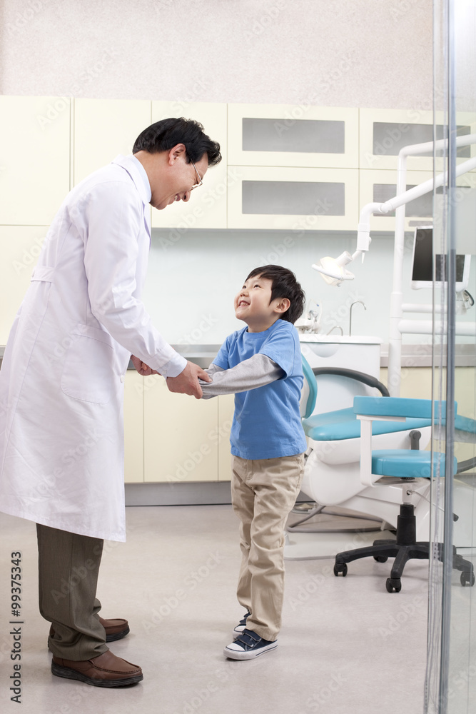 Dentist shaking hands with a little patient