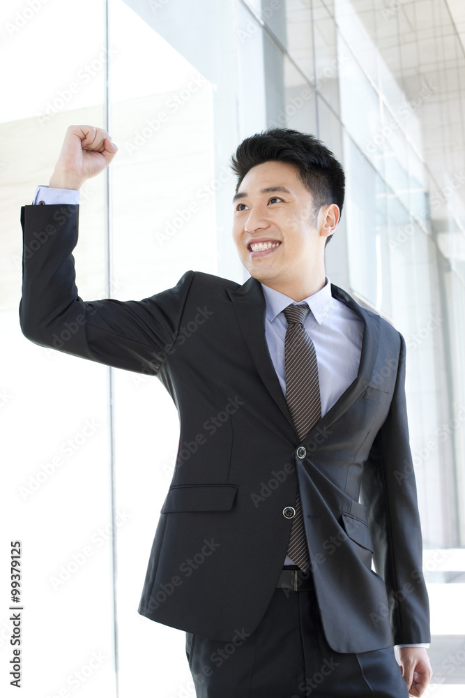 Cheerful businessman punching the air in CBD