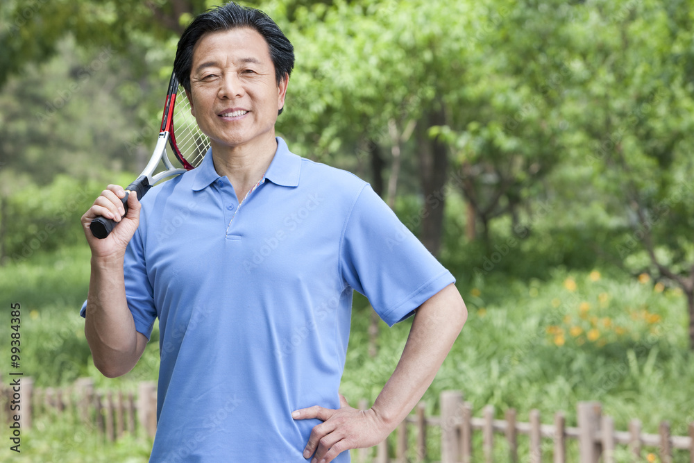 Senior man playing tennis in park