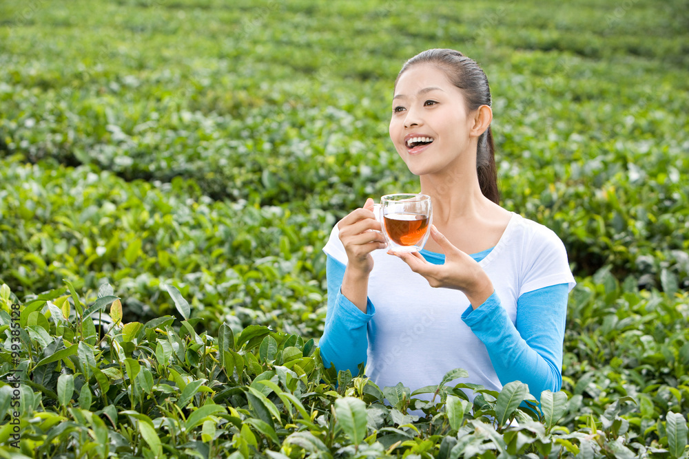 Young Woman Drinking Tea in a Tea Field