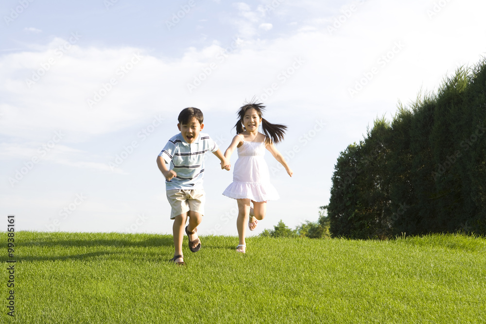 Children holding hands and running outdoors