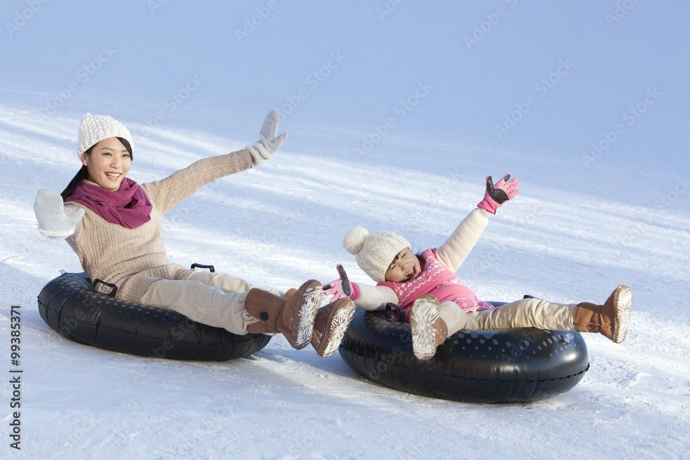 母亲和女儿在雪地里玩得很开心