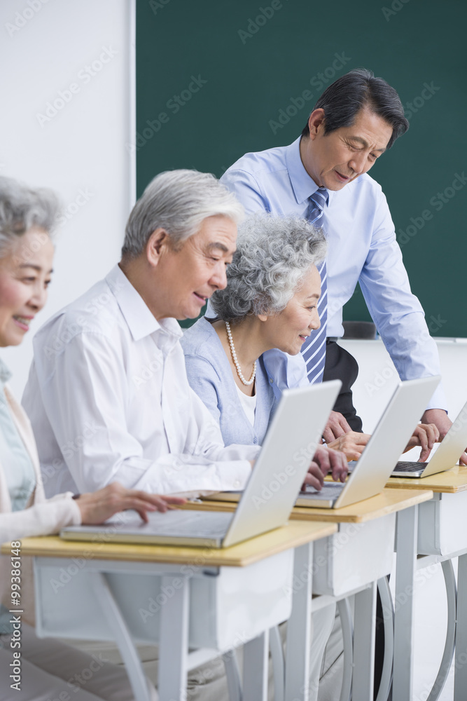 在学校上电脑课的老年人