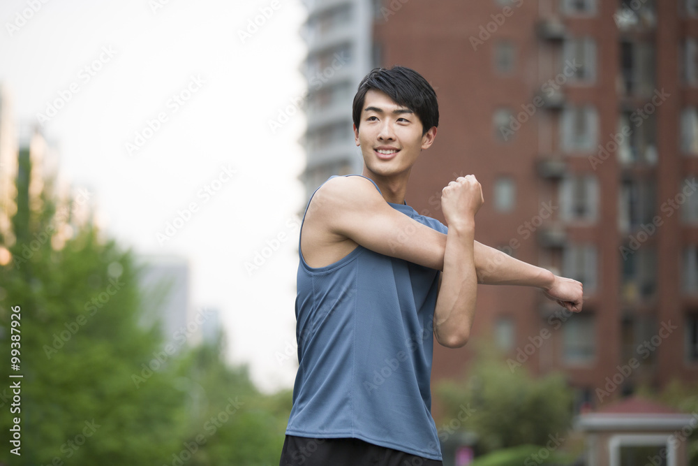 Young man stretching outside